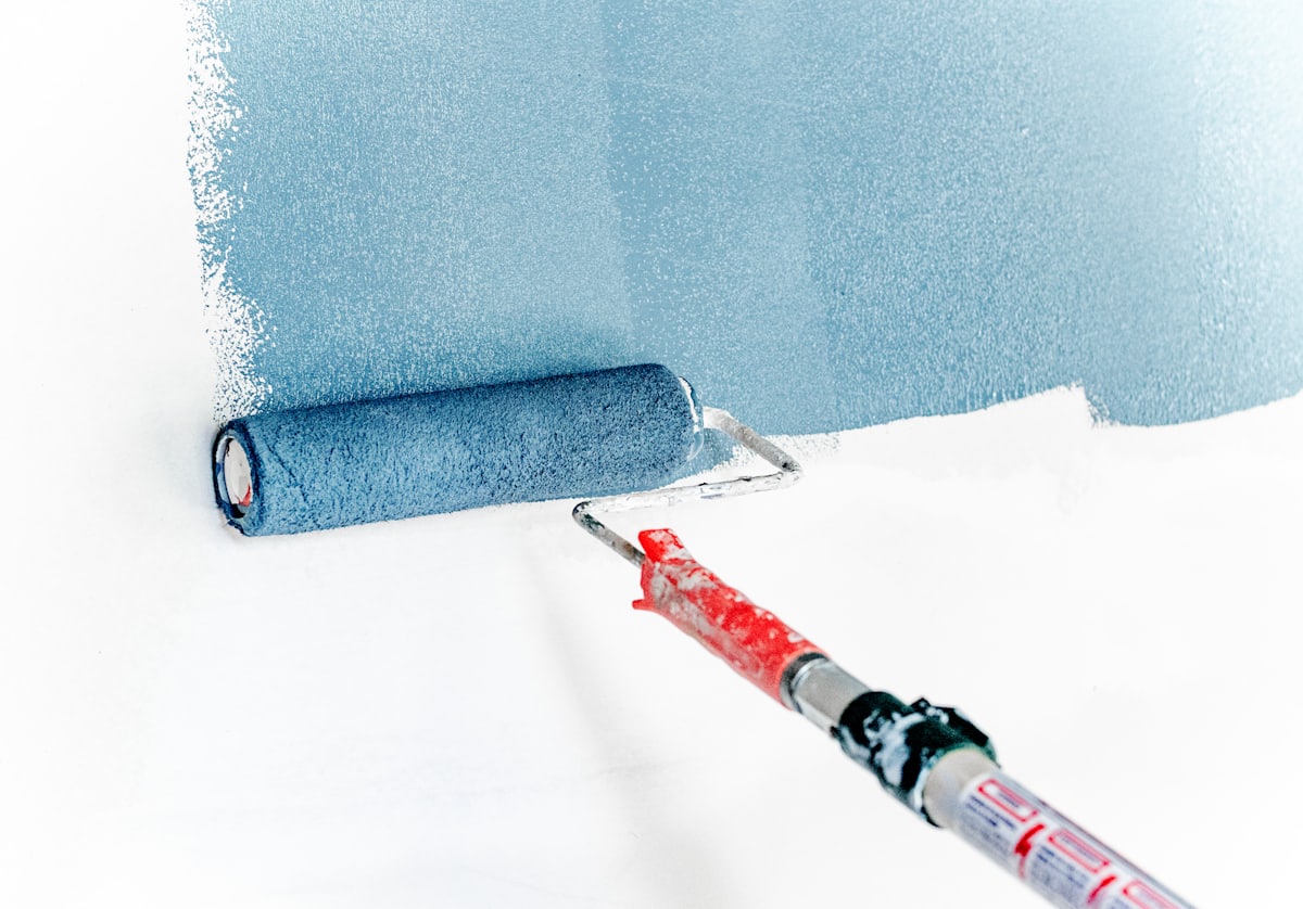 Roller applying a smooth coat of paint to a wall